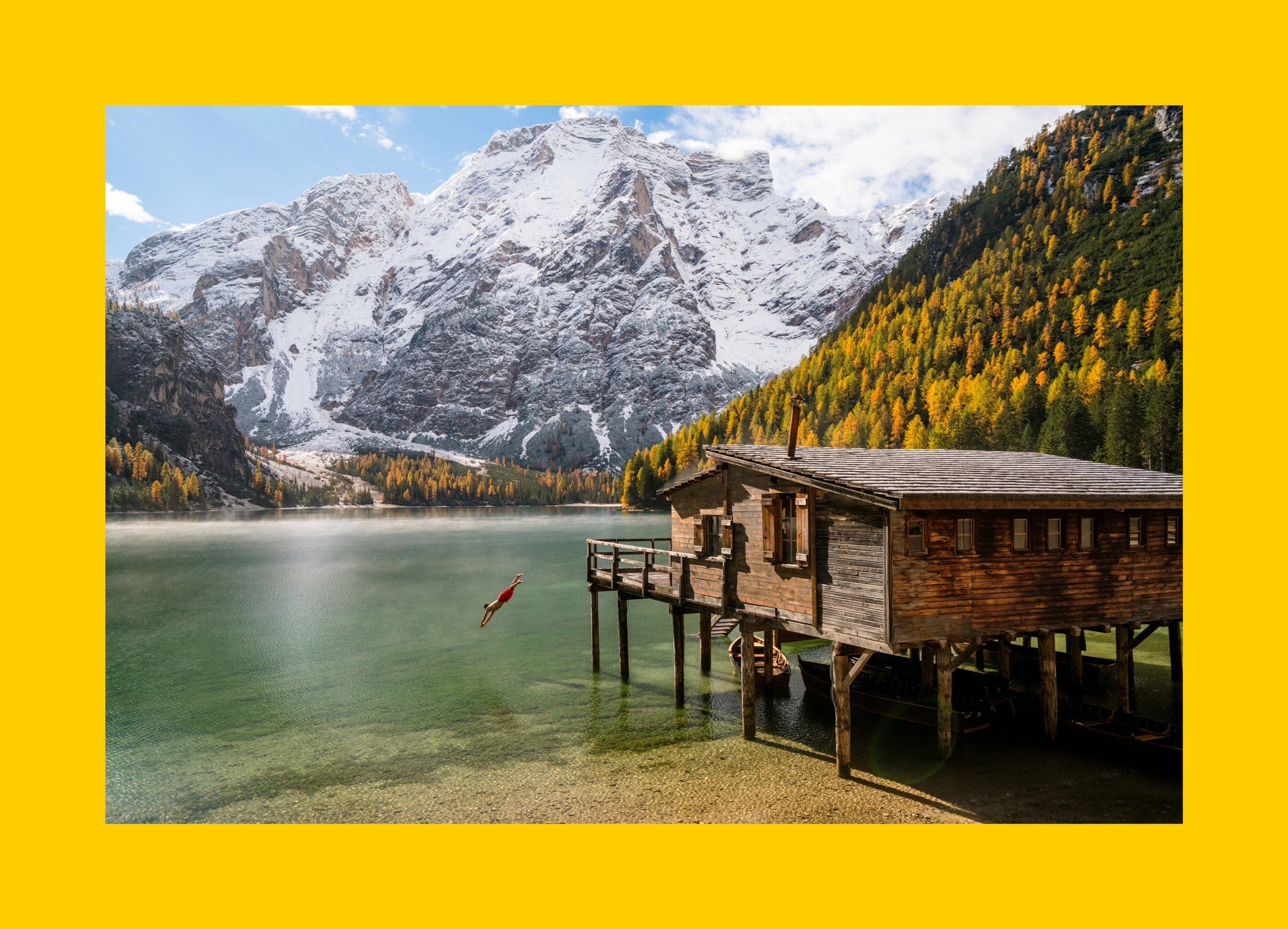 A diver jumps off the patio of a wood house into on Lago de Braies in the Italian Dolomites.