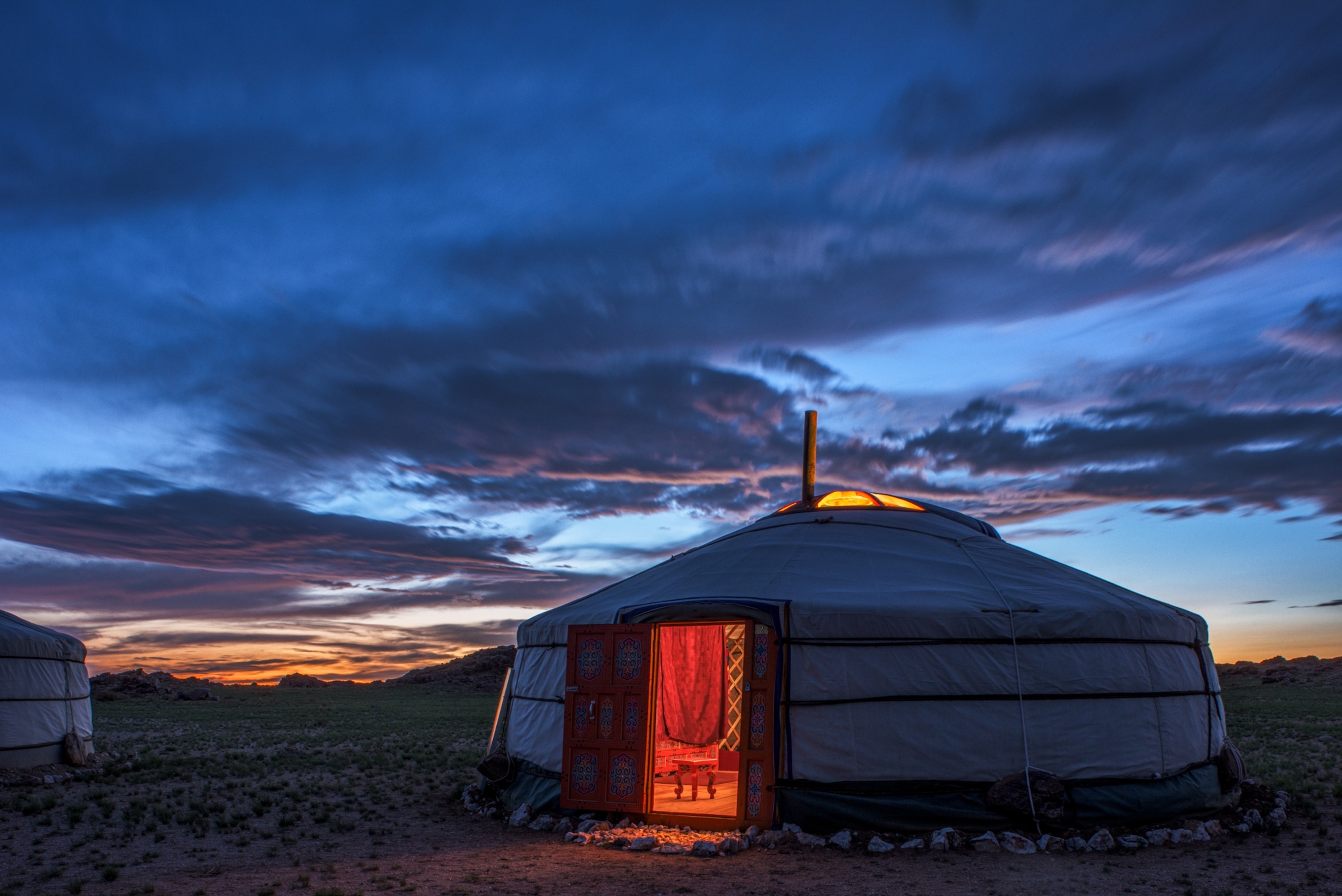 A night shot of a ger with an open door.