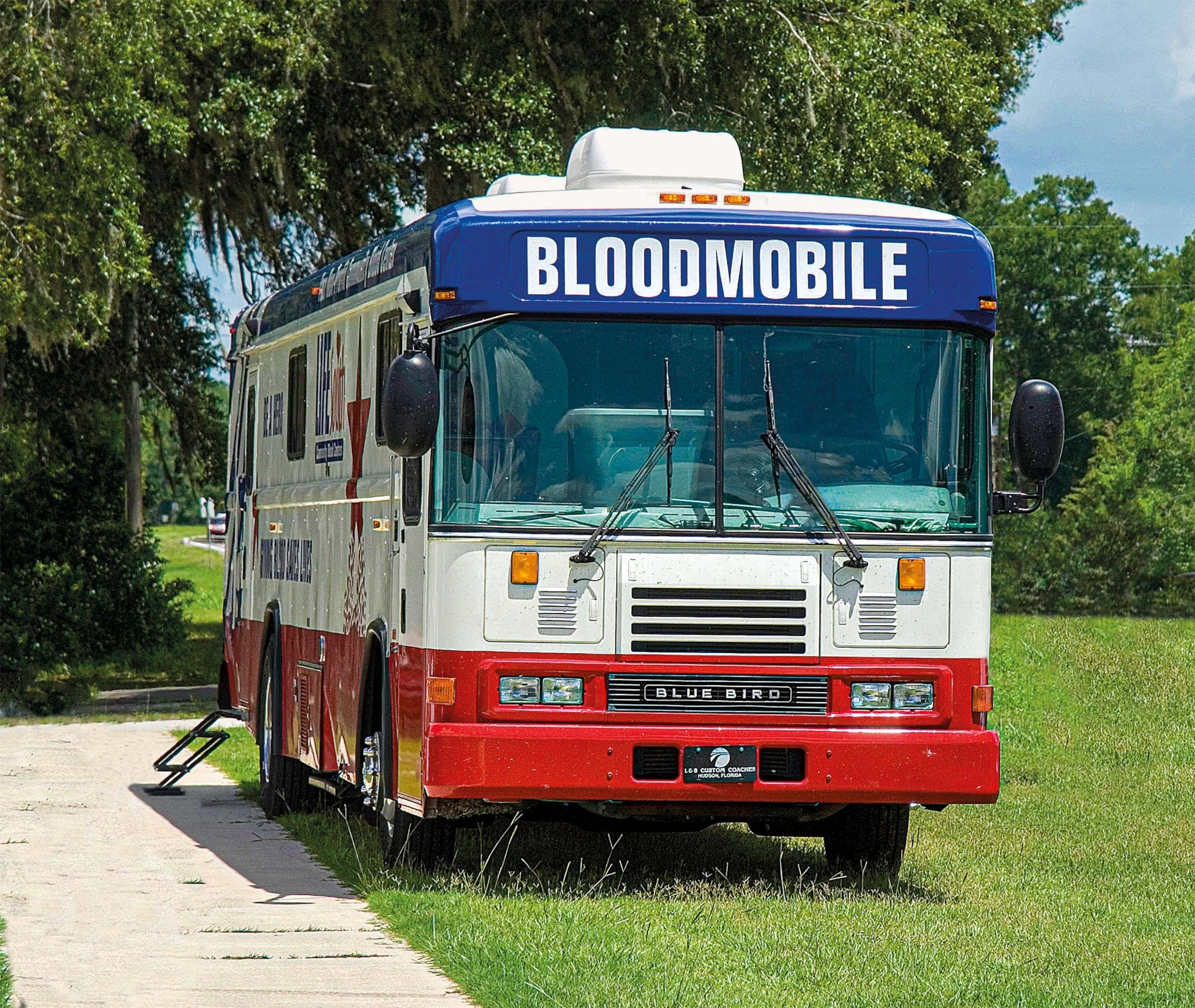 A modern bloodmobile is parked outside a church in High Springs, Florida.