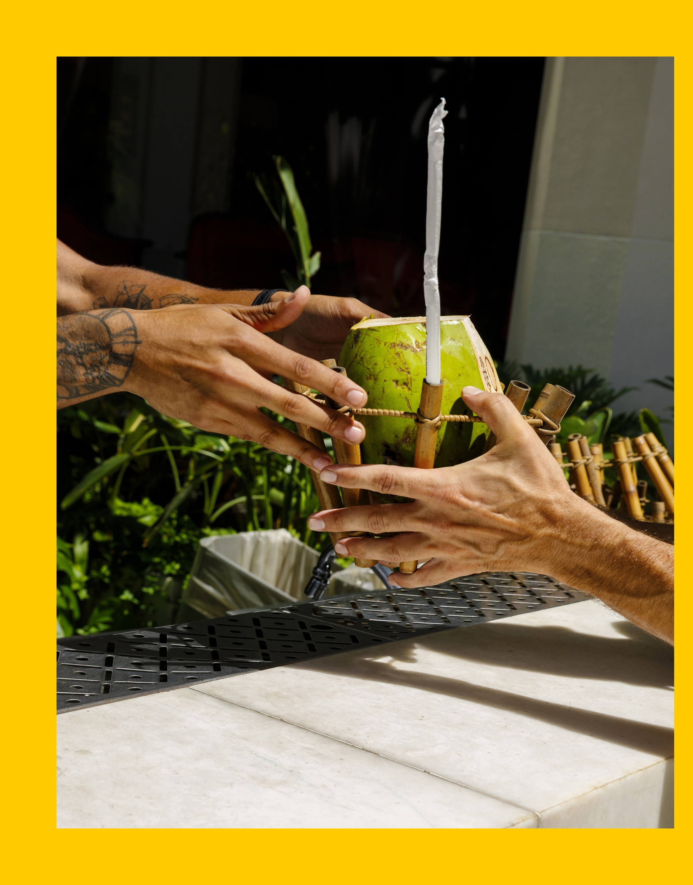 Hands grab coconut water at the iconic Copacabana Palace Hotel, Rio de Janeiro, Brazil.