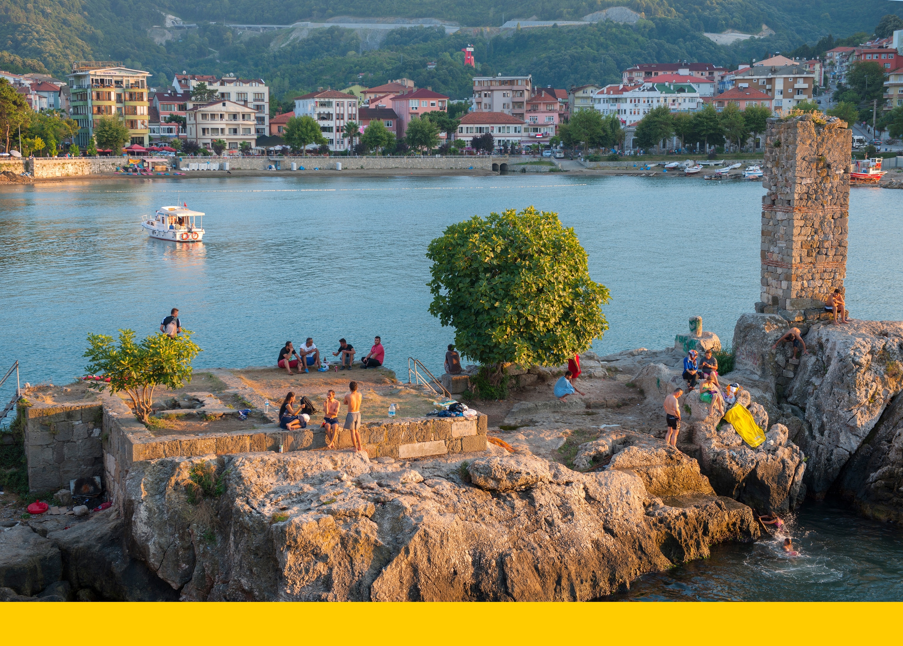 In Amasra, Türkiye, tourists and residents converge on Direkli Kaya (Pillar Rock) to swim in the Black Sea.