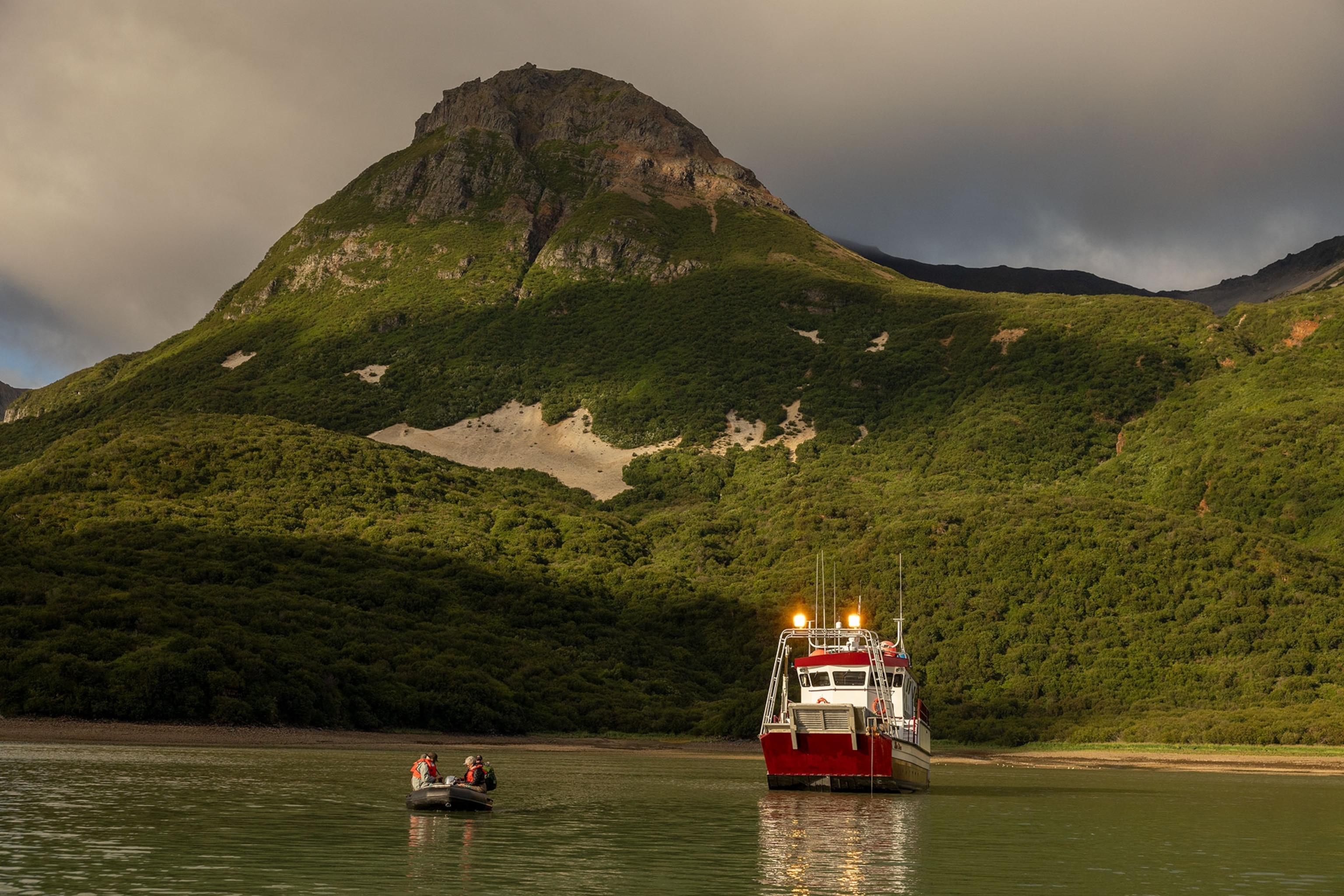 A zodiac full of passengers departs the M/V Miss Diane in Geographic Harbor in Alaska's Katmai National Park