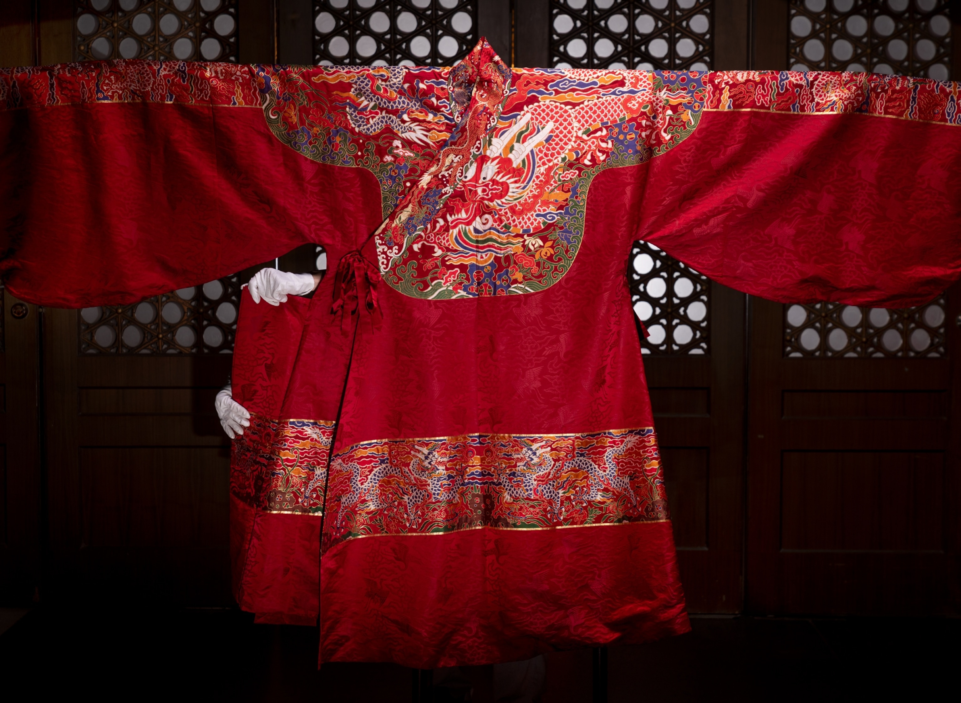 Robe with intricate design mostly in gold and red colors.