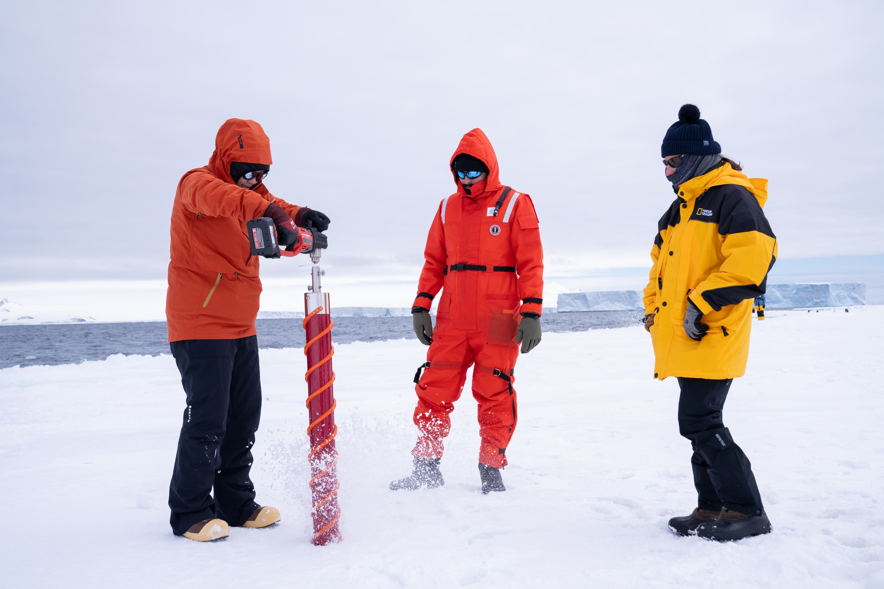 National Geographic Explorer and oceanographer Allison Fong (left), along with marine biologist Joao Bosco Gusmao (middle), and the Educator and Grosvenor Teaching Fellow, Lyanne Abreu (right), extract an ice core on an Antarctic ice floe.